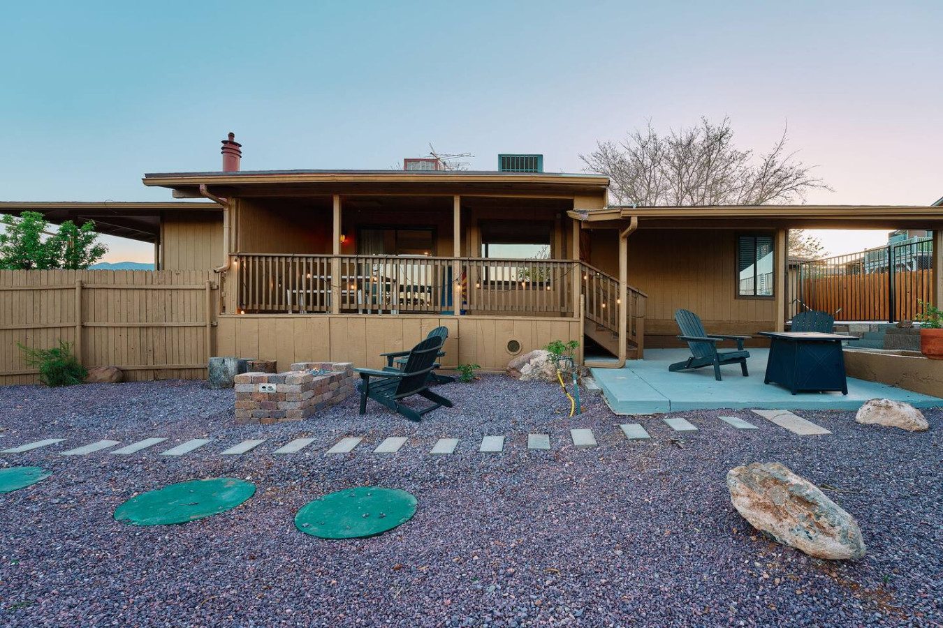The Cottonwood Castaway at twilight with warm porch lights and desert landscaping