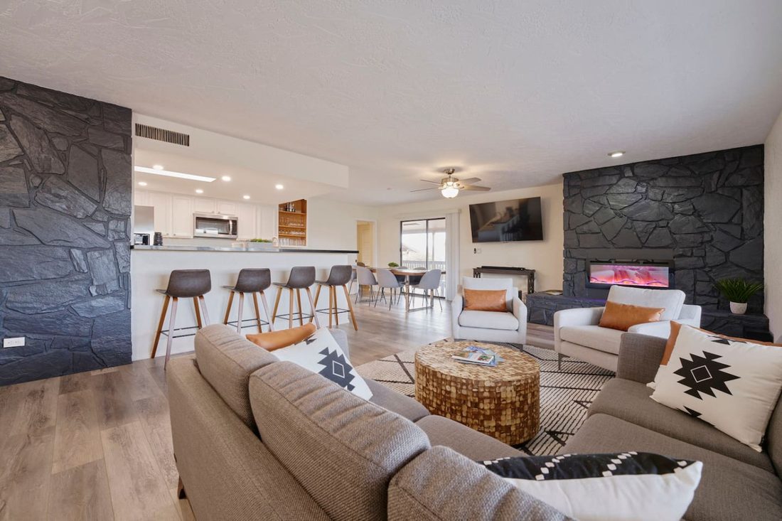 Open living room with a stone fireplace, sectional sofa, and Southwest decor